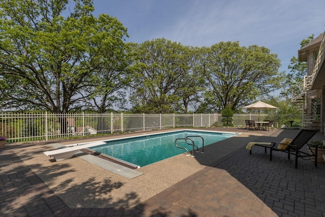 view of pool featuring a diving board and a patio area