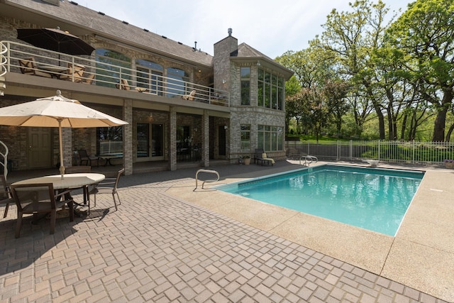 view of pool with a diving board and a patio area