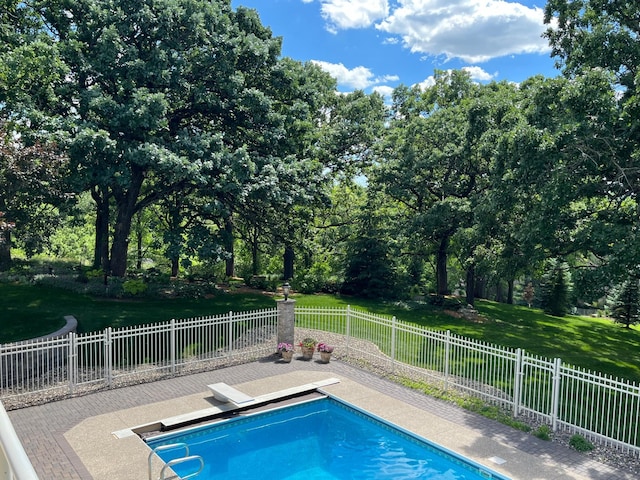 view of pool with a diving board and a patio