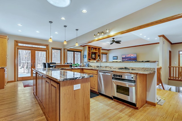 kitchen with light stone countertops, light hardwood / wood-style floors, stainless steel appliances, kitchen peninsula, and ceiling fan