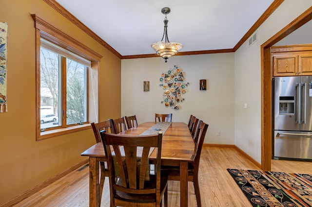 dining room featuring ornamental molding and light hardwood / wood-style floors