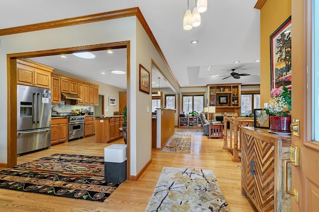 kitchen featuring high end appliances, light hardwood / wood-style floors, crown molding, hanging light fixtures, and ceiling fan