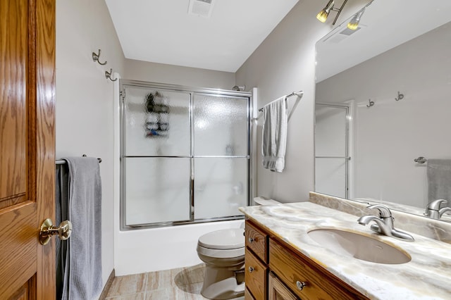 full bathroom with vanity, toilet, enclosed tub / shower combo, and tile patterned flooring