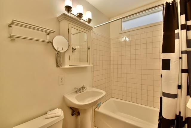 bathroom featuring toilet and shower / tub combo