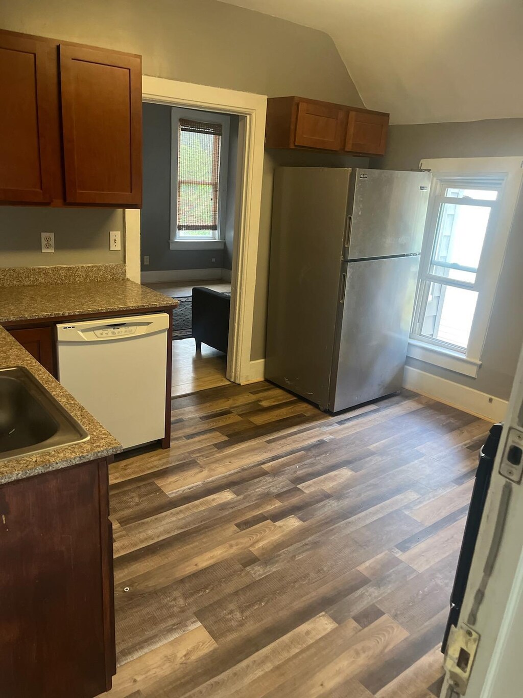 kitchen with freestanding refrigerator, vaulted ceiling, dark wood-style floors, and dishwasher