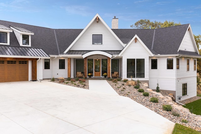 935 Lakewood Hills Rd, Eagan, MN 55123 - modern farmhouse style home featuring a standing seam roof, a porch, a chimney, and concrete driveway