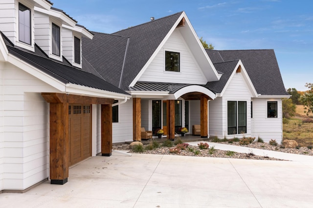 935 Lakewood Hills Rd, Eagan, MN 55123 - modern farmhouse style home with covered porch, an attached garage, concrete driveway, and metal roof