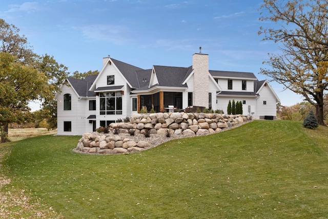 935 Lakewood Hills Rd, Eagan, MN 55123 - rear view of house featuring a sunroom, a chimney, and a lawn