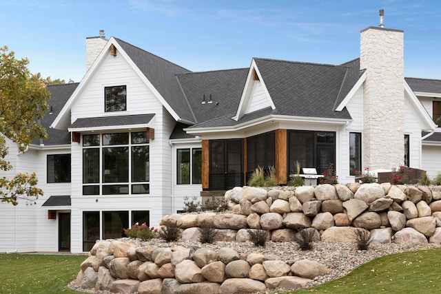 935 Lakewood Hills Rd, Eagan, MN 55123 - back of house featuring a sunroom, a chimney, and a shingled roof