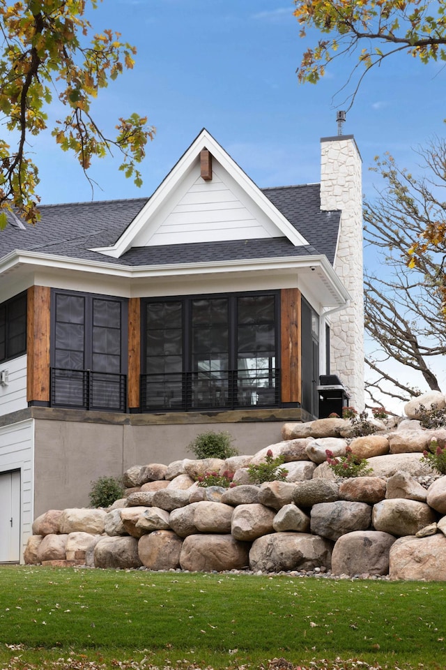 935 Lakewood Hills Rd, Eagan, MN 55123 - view of property exterior with a sunroom, a shingled roof, and a chimney
