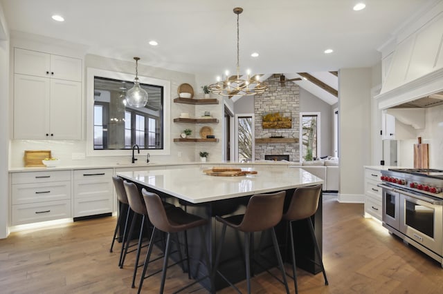 935 Lakewood Hills Rd, Eagan, MN 55123 - kitchen featuring range with two ovens, decorative backsplash, light countertops, a stone fireplace, and a breakfast bar