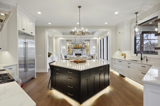 935 Lakewood Hills Rd, Eagan, MN 55123 - kitchen featuring stainless steel built in refrigerator, a sink, dark cabinetry, white cabinetry, and a kitchen island