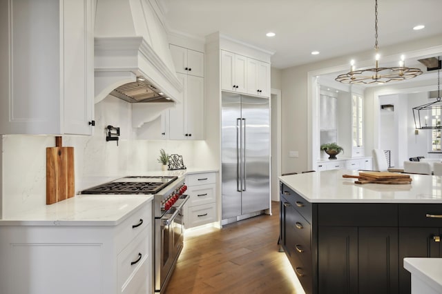 935 Lakewood Hills Rd, Eagan, MN 55123 - kitchen featuring premium appliances, a chandelier, custom exhaust hood, wood finished floors, and white cabinetry