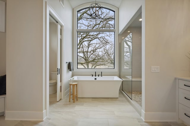 935 Lakewood Hills Rd, Eagan, MN 55123 - bathroom featuring a freestanding bath, baseboards, toilet, a chandelier, and a shower stall