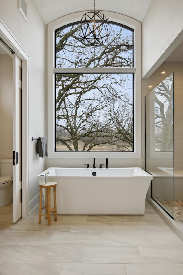 935 Lakewood Hills Rd, Eagan, MN 55123 - full bath with healthy amount of natural light, a soaking tub, toilet, a chandelier, and vaulted ceiling