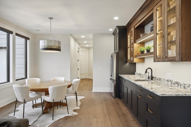 935 Lakewood Hills Rd, Eagan, MN 55123 - kitchen with a sink, freestanding refrigerator, light wood-type flooring, glass insert cabinets, and recessed lighting