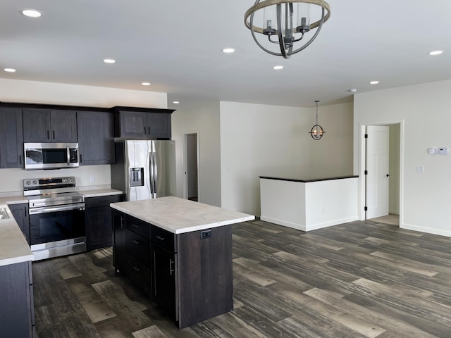 kitchen with a kitchen island, pendant lighting, a notable chandelier, dark wood-type flooring, and stainless steel appliances