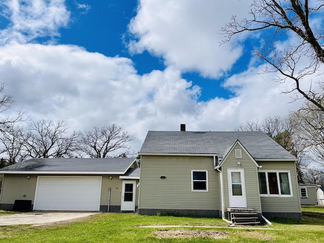 view of front facade with a front yard, central AC, and a garage