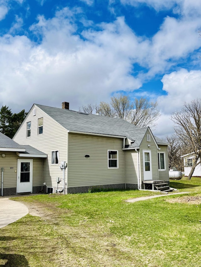 back of house featuring a lawn