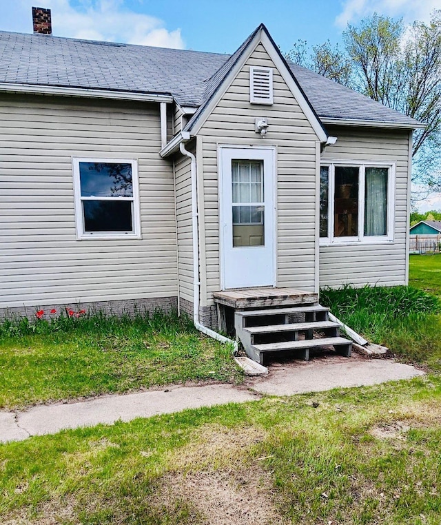 view of exterior entry with a yard