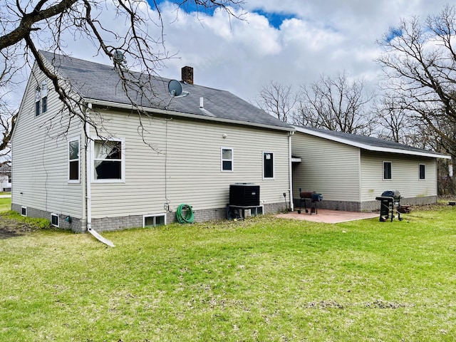 rear view of property with central air condition unit, a lawn, and a patio