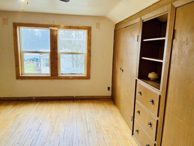 empty room with ceiling fan, light hardwood / wood-style flooring, and lofted ceiling