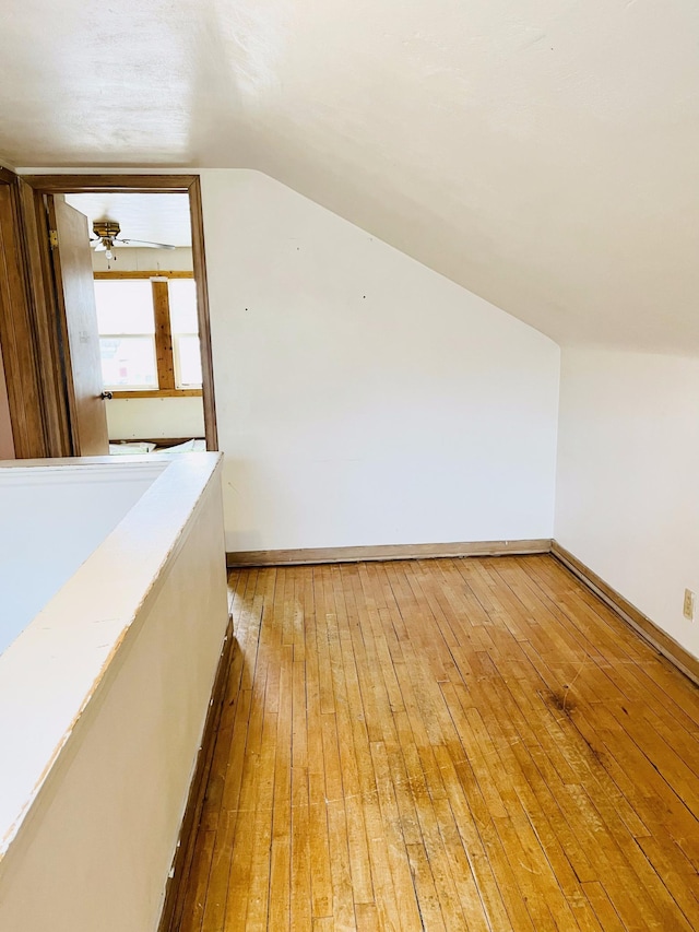 additional living space with vaulted ceiling and light wood-type flooring