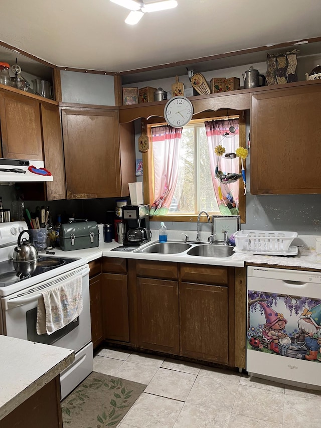 kitchen featuring sink, light tile patterned flooring, white appliances, and decorative backsplash