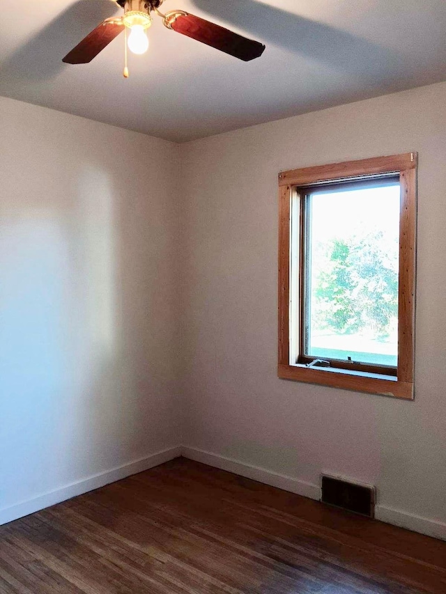 empty room featuring ceiling fan and dark wood-type flooring