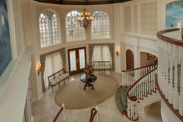 tiled entrance foyer with a notable chandelier, plenty of natural light, and french doors