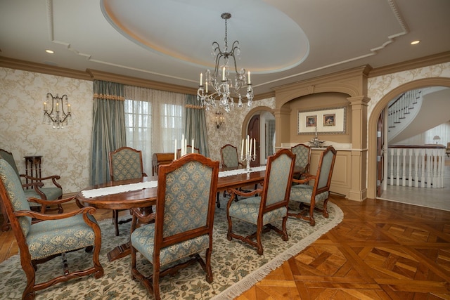 dining area with an inviting chandelier, dark parquet floors, and a tray ceiling