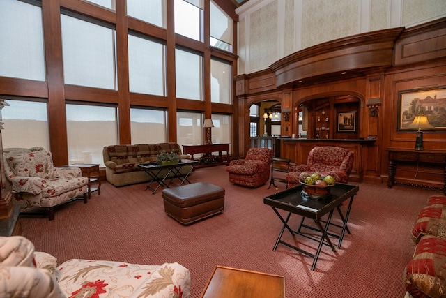 living room with dark colored carpet and a towering ceiling