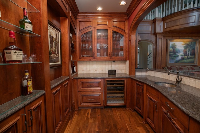 kitchen with sink, tasteful backsplash, dark wood-type flooring, and dark stone countertops