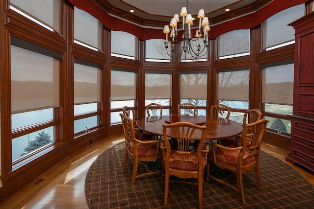 dining room featuring an inviting chandelier, plenty of natural light, a towering ceiling, and dark hardwood / wood-style flooring