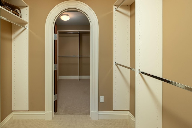 walk in closet featuring light carpet