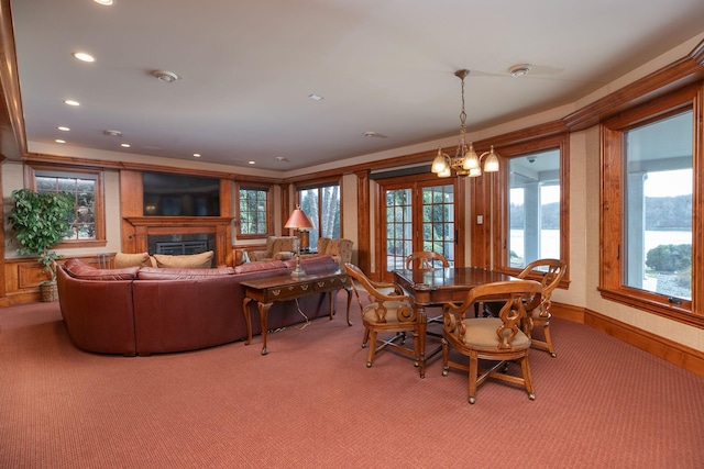 carpeted dining room featuring an inviting chandelier