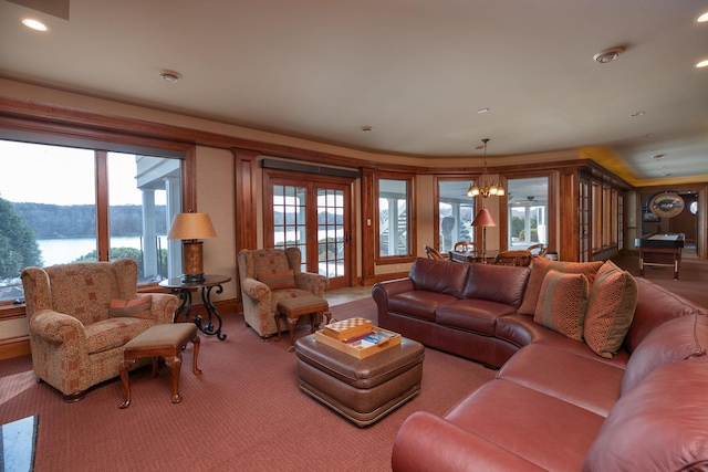 living room with french doors, an inviting chandelier, and a water and mountain view