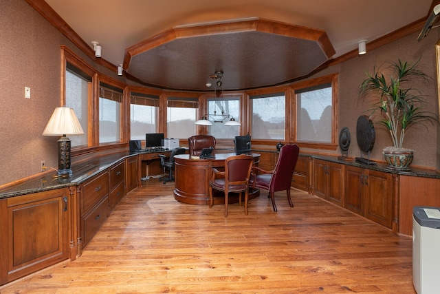 office with built in desk and light wood-type flooring