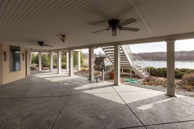 view of patio with a water view and ceiling fan