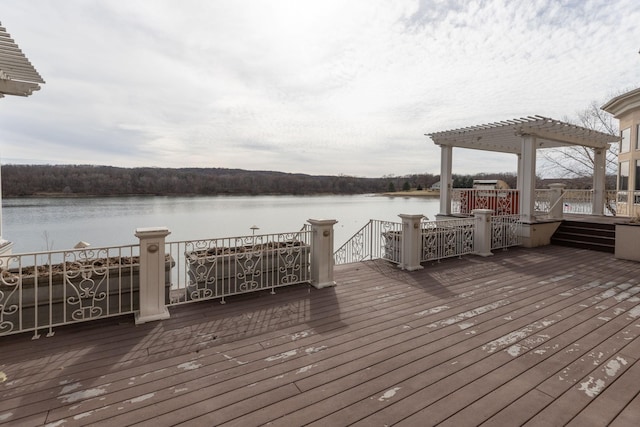 wooden deck featuring a water view and a pergola