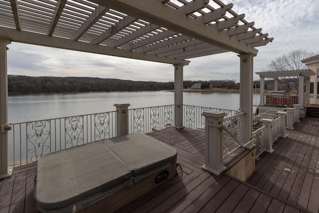 wooden terrace with a covered hot tub, a water view, and a pergola