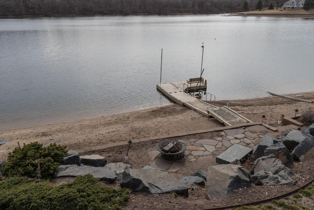 dock area with a fire pit and a water view