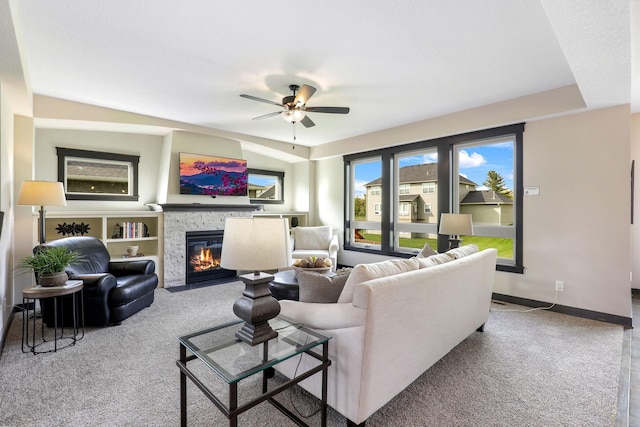 carpeted living room featuring ceiling fan and a fireplace