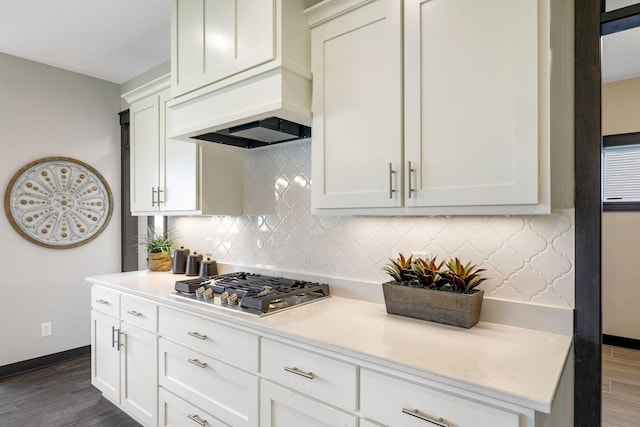 kitchen featuring backsplash, dark wood-type flooring, and white cabinetry