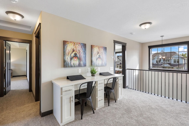 carpeted home office featuring a textured ceiling and an inviting chandelier