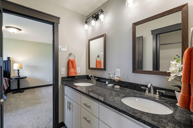 bathroom featuring dual bowl vanity and a textured ceiling