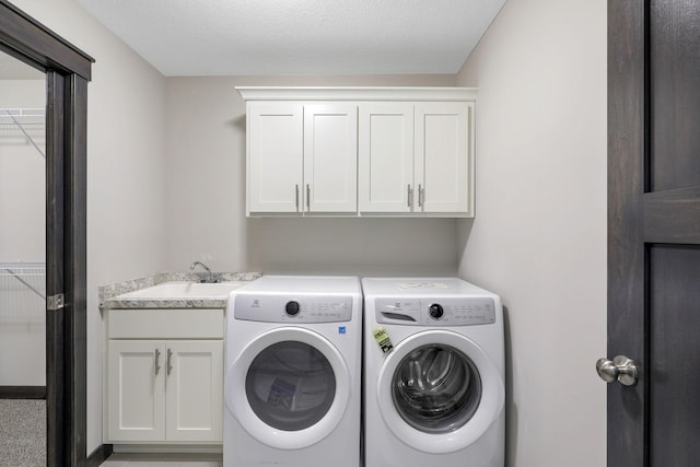 laundry area featuring cabinets, washer and dryer, and sink