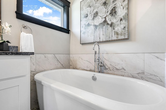 bathroom with a tub and tile walls