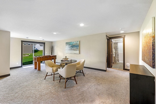 carpeted dining area with a textured ceiling