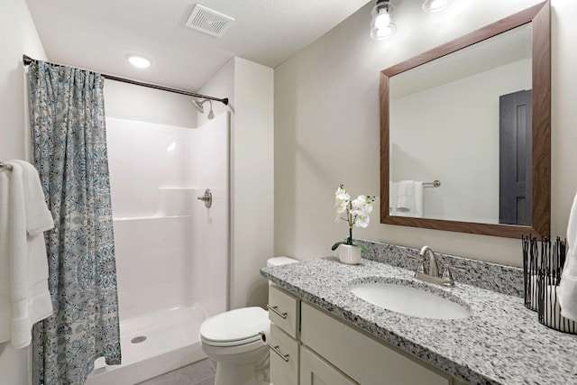 bathroom with tile floors, a textured ceiling, a shower with curtain, toilet, and large vanity